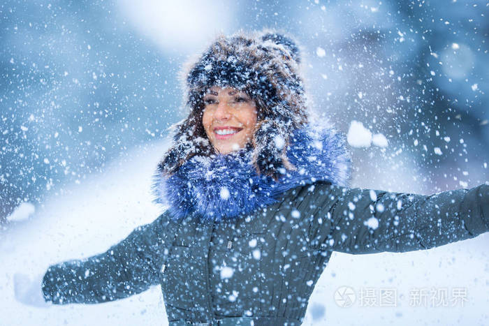 美丽微笑的年轻女子穿着暖和的衣服 冬季雪中画像的概念照片 正版商用图片0en0n1 摄图新视界