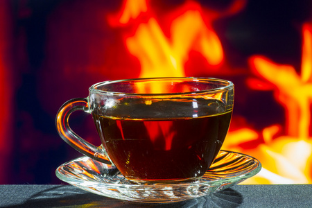 玻璃杯红茶,背景为火照片