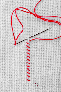 白色织物用红线和缝纫针制成的刺绣针
