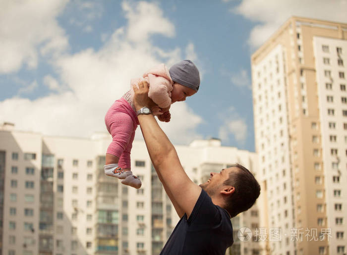 爸爸抱在怀里的女儿.城市背景