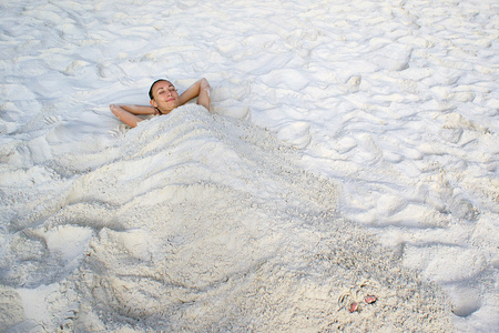 女孩躺在白色的沙滩上