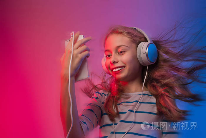 智能手机和耳机的女孩听音乐