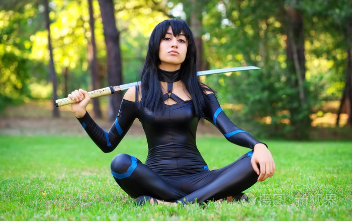 年轻的女孩坐在草地上,拿着武士刀.origi