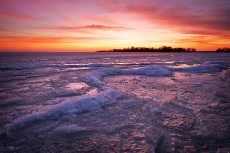 冬季景观与湖和日落火红的天空