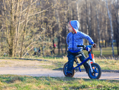 小男孩在公园里跑步自行车