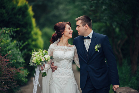 迷人的高加索婚礼情侣鲜花花束拥抱在公园一对美丽的情侣在结婚拱门