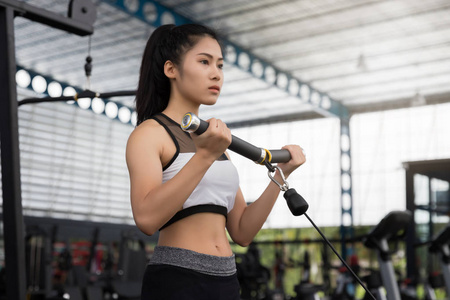 特写在体育俱乐部的一个年轻的健身亚洲妇女锻炼
