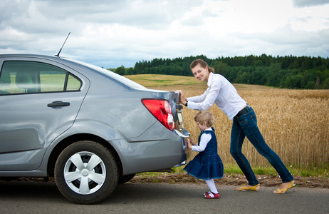 妈妈帮女儿穿鞋女儿帮妈妈推车照片