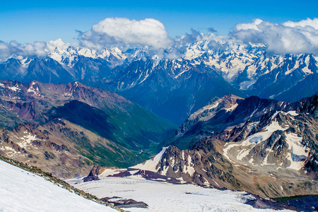 风景秀丽的雪山的全景照片山顶上的登山者顶着蓝雪覆盖的山脉.