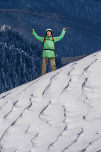 快乐的年轻人背包站在白雪皑皑的山坡上。登山或山的徒步旅行者