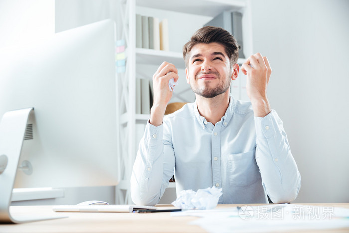 在办公室里工作的生气懊恼年轻商人