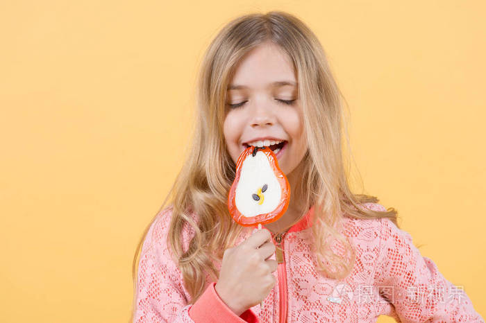 可爱的小孩子喜欢吃甜食糖果橙色背景, 复制空间照片