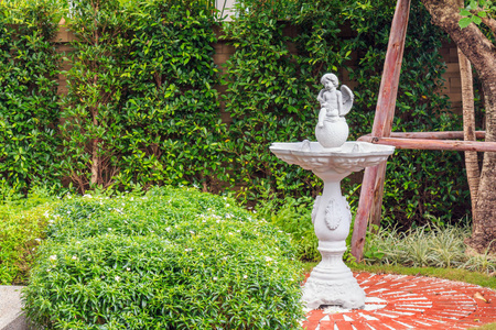 小天使雕像在庭院的喷泉在石头