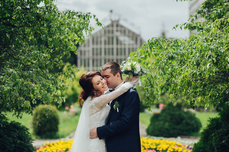 快乐高加索婚礼情侣鲜花花束拥抱在公园
