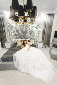 新娘穿着白色的婚纱礼服在卧室的床上