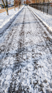 雪中沥青的特写。在城市的道路在冬天, 清理雪清理街道从雪在公园
