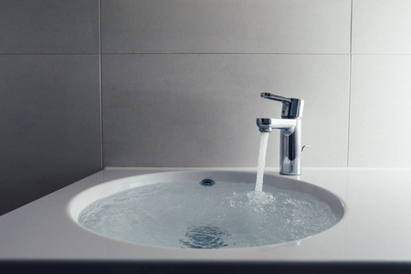 龙头流水洗涤水槽中的流水水龙头照片