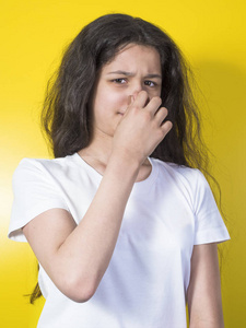 年轻女孩抱着她的鼻子闻到臭气熏天照片