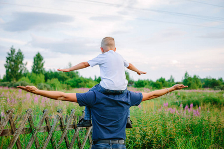 儿子坐在他父亲的肩膀上照片