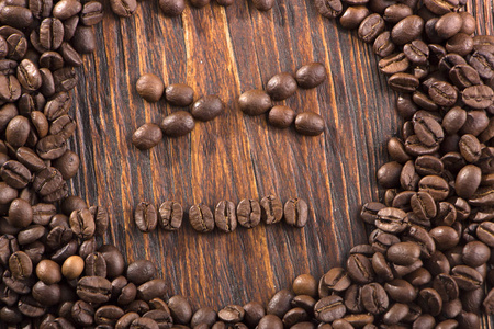 在白木背景下烤咖啡豆的微笑形状