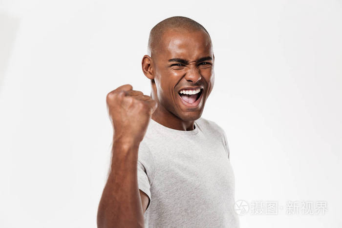 站在孤立的情感年轻的非洲男人使胜利者的姿态