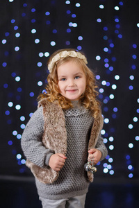 时尚打扮的女孩与皇冠近圣诞树与礼物