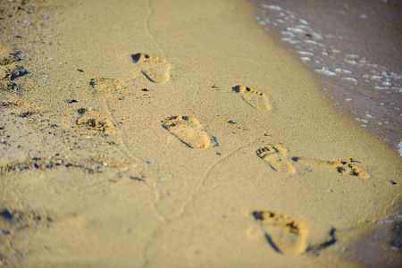 在海边漫步的情侣在沙滩上留下了印记