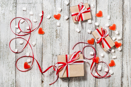 情人节糖果心软糖和工艺纸的礼物盒白色木背景
