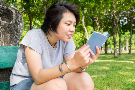 在公园里的亚洲女孩阅读书