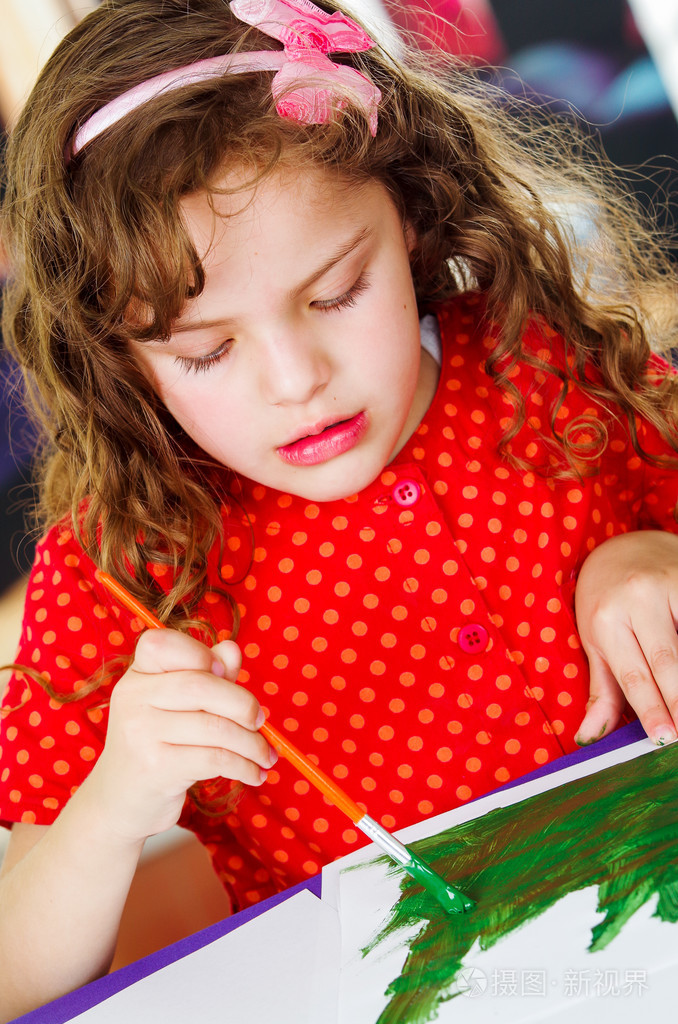 甜美的女孩拿着画笔绘画