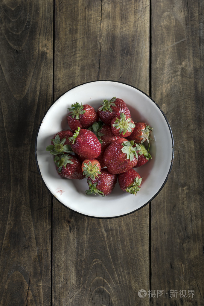 在木制的桌子上一碗草莓
