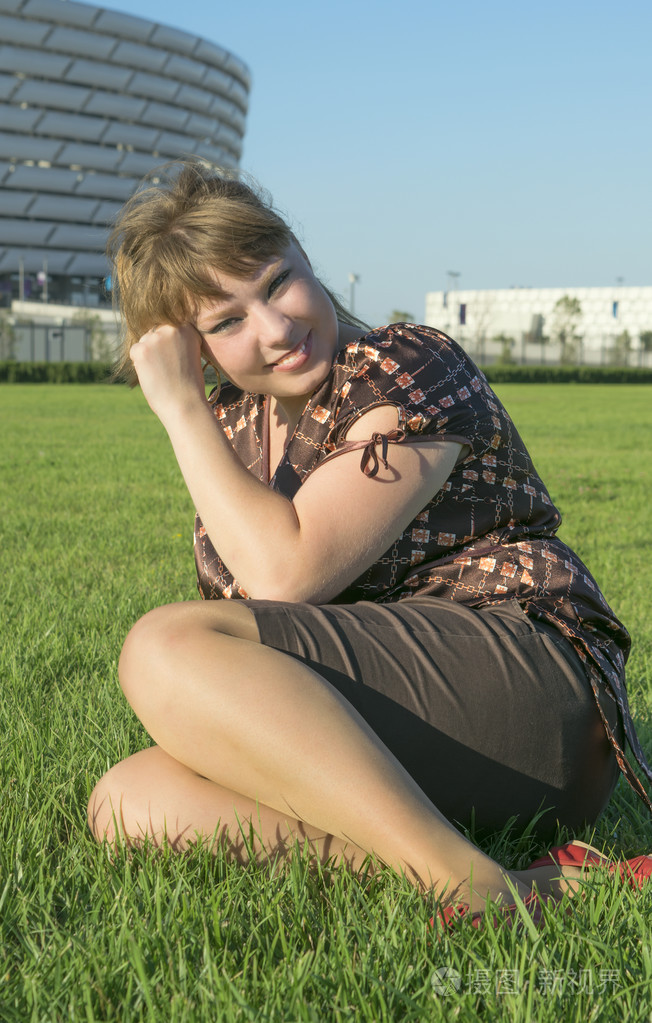 坐在绿草地上的胖女人