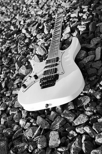 黑色和白色电吉他上的铁轨和石