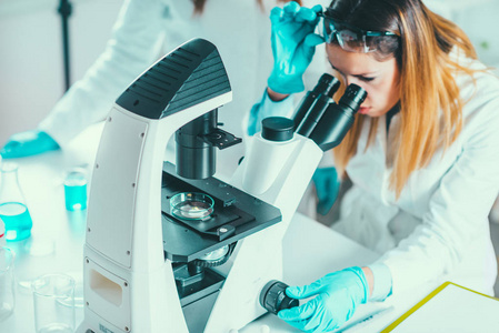 生命科学研究, 女性研究员在显微镜下放置样本照片