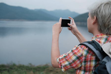 旅行者徒步旅行人与背包远足在湖附近。旅游 backp