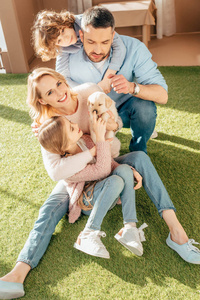 快乐的年轻家庭与拉布拉多小狗在院子里的纸板房子