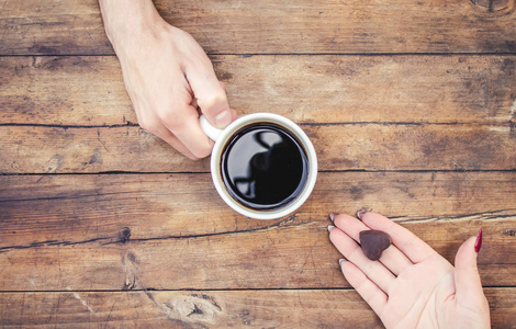 杯中的咖啡在男人和女人的手中。选择性焦点