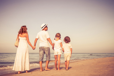 幸福的家庭，海滩上散步，在白天的时间