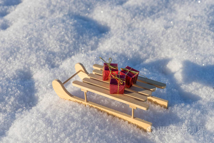 雪中木制雪橇上的红色礼物