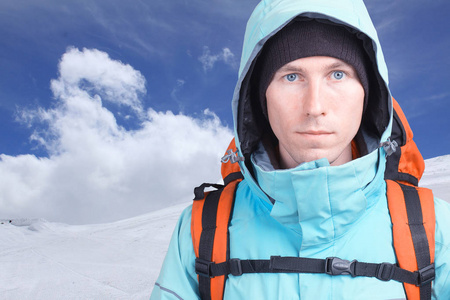年轻男子登山冬季山区的画像。蓝蓝的天空和洁白的云朵