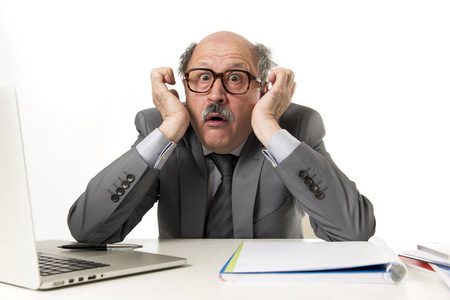 成熟的业务男子与光头在他的60s 工作压力和沮丧的办公室电脑笔记本电脑办公桌看起来绝望