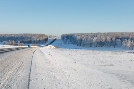公路穿过森林。冬天路