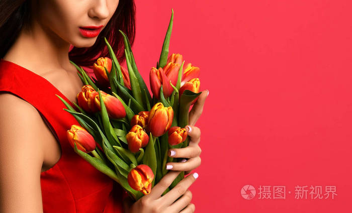 美丽的女人与花束的郁金香花在红色礼服
