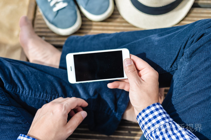 坐着手里拿着手机的时尚人的顶视图