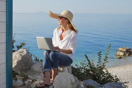 女人在海滩上使用笔记本电脑