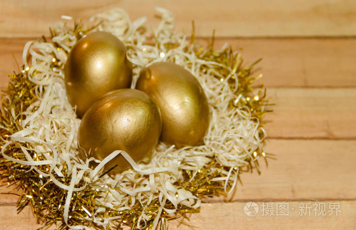 金复活节彩蛋在稻草巢与乡土木背景