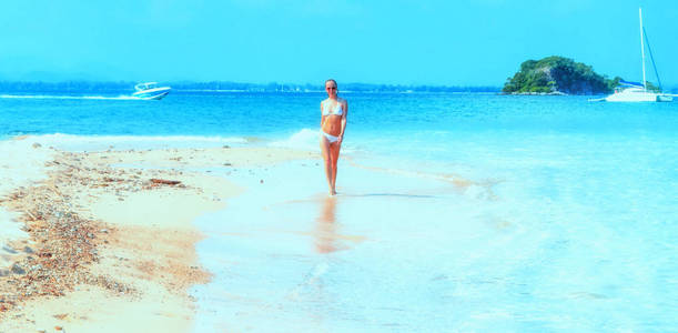 在泰国沙美岛海滩漫步的年轻女子