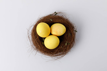 白色装饰巢中黄色彩绘复活节彩蛋的顶部视图