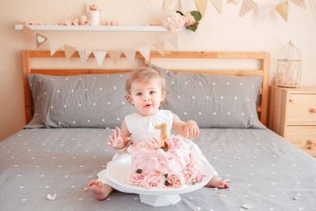 可爱的白种白人金发碧眼的女婴的肖像, 庆祝她的第一个生日。首页室内蛋糕粉碎第一年概念