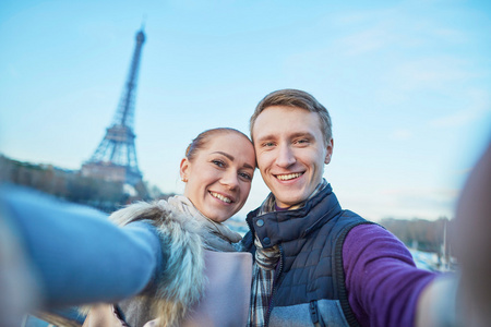 幸福的夫妇的游客在巴黎的埃菲尔铁塔附近的自拍照